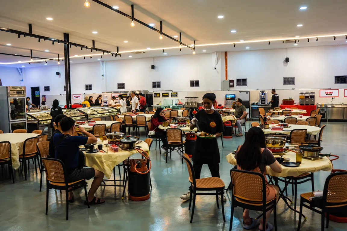 Ruang makan dengan meja steamboat dan kaunter buffet di QQ JB, Masai